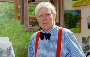 Older man wearing blue gingham shirt with black bow tie and red braces