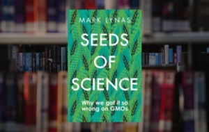 Seeds of Science cover on background of bookshelf