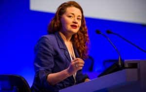 Dr Hannah Barham Brown wearing a blue suit speaking at an event