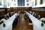 people sitting at a formal dinner setting in hall