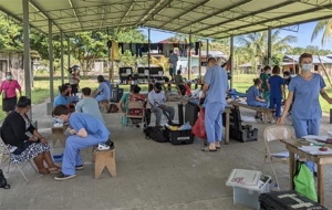 Medical field tent with several people in scrubs treating people