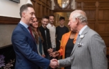 The Prince of Wales shaking hands with andrew bell, others watch on