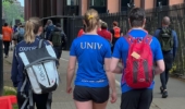 the backs of three runners two with blue tops with univ on them