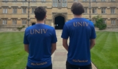 the back of two runners showing univ logo and go team univ