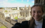 Blonde woman smiling at top of church looking over Oxford