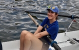 a women in a univ t-shirt sitting in a boat
