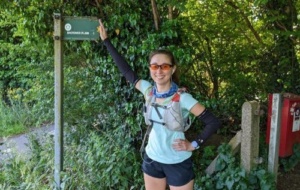 Woman smiling standing beside the Oxford Green Belt Way sign