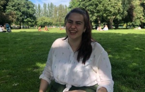 Woman wearing a white shirt smiling sitting a park