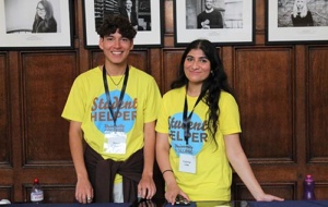 two smiling student helpers with yellow t-shirts