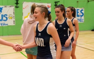 Woman in Oxford netball uniform shaking hands with opponents