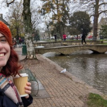 Woman smiling wearing red knit hat in picturesque village