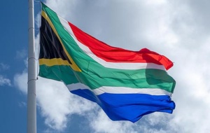 South African flag fluttering on a pole against a blue sky