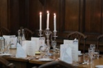 a table with candles and menu cards set for a formal dinner