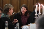 two women in conversation seated at a formal dinner setting