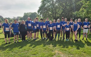 large group of runners in blue Univ t-shirts in a field