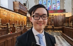 Man in suit with black-rimmed glasses in the College's chapel 