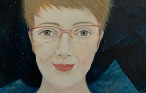 Woman smiling with short blonde pixie cut and half-rimmed glasses