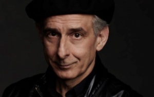 Charismatic middle-aged man staring at the camera, wearing all black