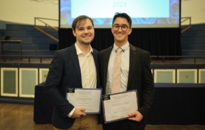 Two people holding awards
