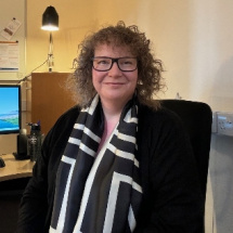 Person with brunette curly hair sitting in office