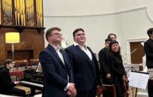 Three people standing in recital hall receiving prizes