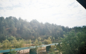 a view of the canyon with a river and green forest